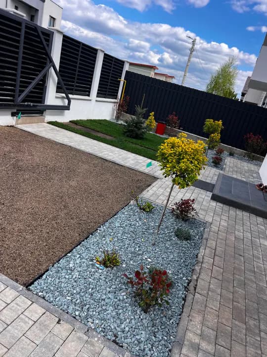 Curte modernă cu pietriș decorativ, gazon și arbuști ornamentali — Iași